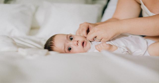 Baby ligger på en seng